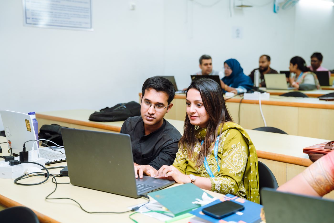Faculty working on laptops during an FDP session